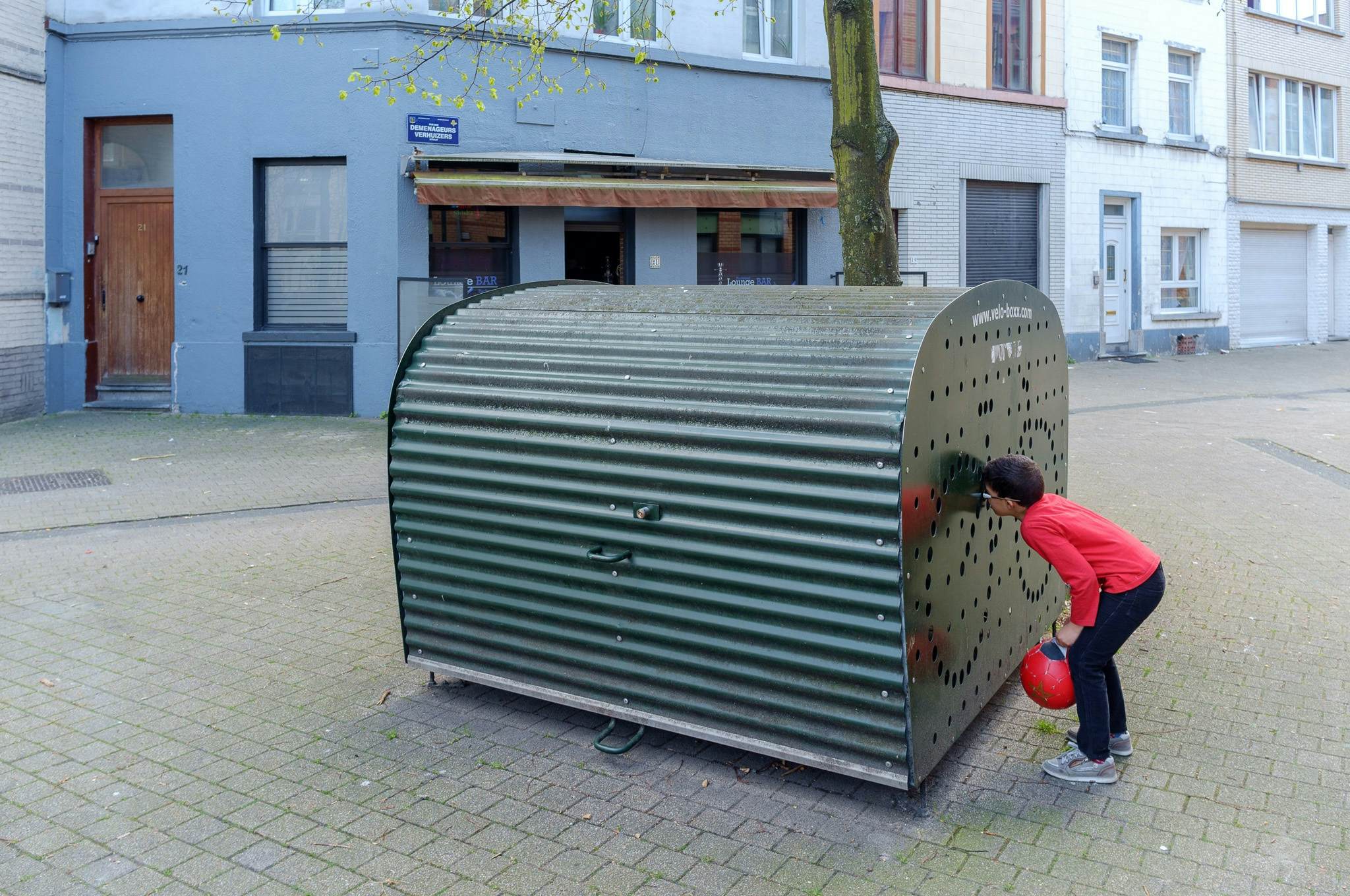 Enfant regardant à l'intérieur d'un box à vélos